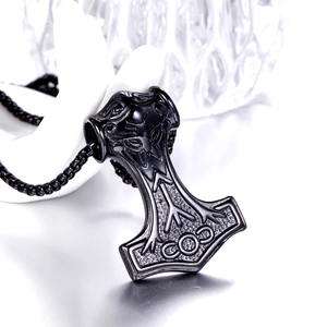 Macro detail of black stainless steel Mjolnir pendant with intricate Viking runes