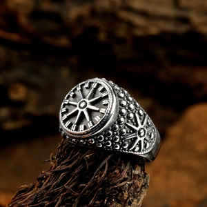 Detailed macro shot of vintage Viking compass ring with antique silver finish on wood