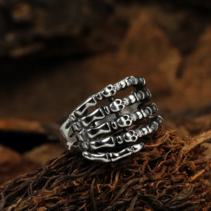 Macro shot of gothic skeleton hand ring with miniature skulls in vintage punk style