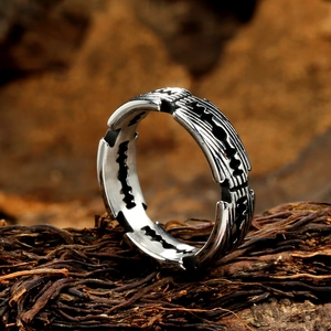 Bague vintage style punk lame de rasoir en acier mat posée sur un tronc en bois rustique