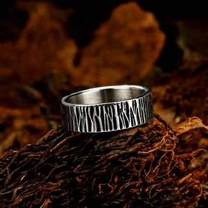 Industrial vintage stainless steel ring with vertical textures on weathered wood
