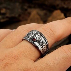 Macro detail of retro snake ring with red rhinestone eyes and textured scales