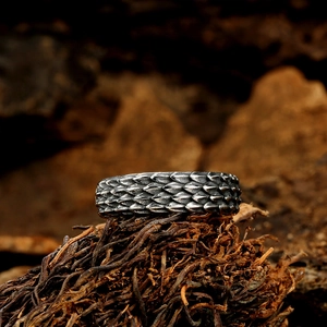 Macro detail of men's vintage stainless steel ring with textured dragon scale pattern