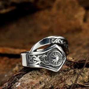 Macro shot of vintage sun god relief on silver stainless steel ring with rustic wood background