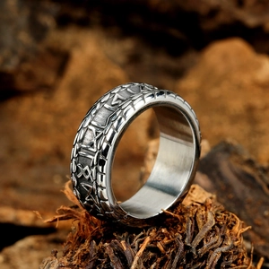 Vintage Nordic rune engraved stainless steel ring for men on a rustic wood background