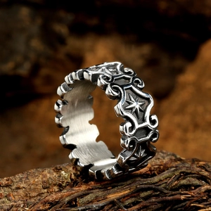 Vintage cross star pattern stainless steel ring on natural bark texture background