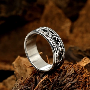 Vintage silver anchor cross ring with detailed vine relief on a rustic bark background