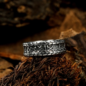 Macro shot of Viking rune ring with vintage Nordic engraving on a textured wood background