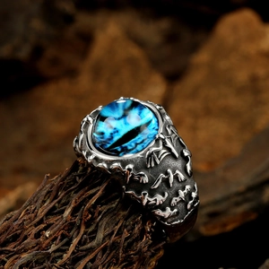 Macro di un anello vintage in acciaio con pietra blu e incisioni di uccelli