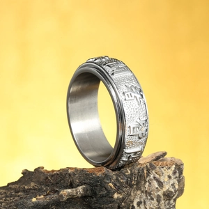 Macro detail of vintage spinning ring with embossed Chinese Nine Words of Power