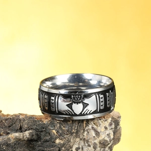 Punk style Claddagh ring in black and silver steel featuring crown heart on wood bark