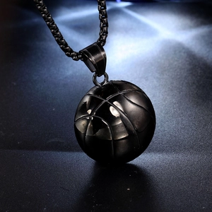 Detailed close-up of a black titanium basketball pendant with textured sports grip lines