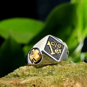 Punk 1%er men's titanium steel ring with gold skull relief on natural stone background