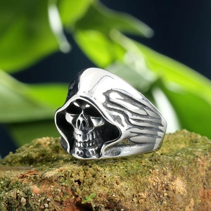 Macro shot of a punk skull ring with detailed engravings on a mossy brick surface