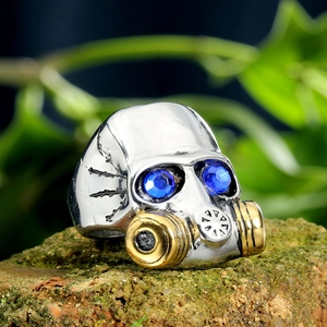 Macro shot of punk skull gas mask ring with blue rhinestones on a natural stone base