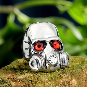 Macro detail of punk skull ring featuring red gemstone eyes and aged silver metal texture