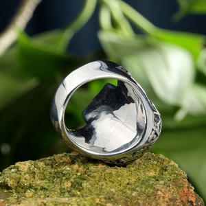 Detailed side view of vintage totem engravings on a retro steel bearded skull ring