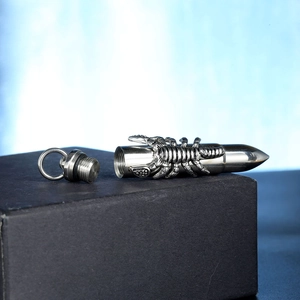 Macro detail of bullet pendant with scorpion relief and screw top opening for storage
