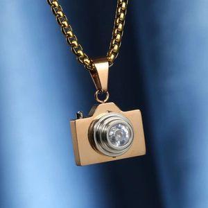 Collier pendentif appareil photo doré avec zircon sur fond de soie bleue élégant