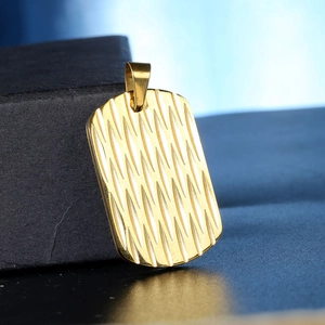 Detail of golden military tag pendant with textured wave pattern on black stand