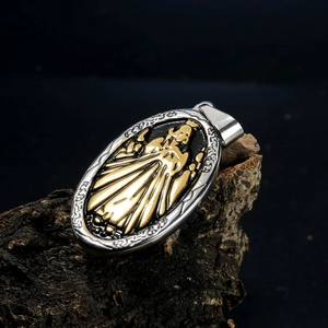 Macro shot of oval two-tone Virgin Mary pendant on bark with polished metal details