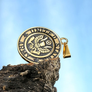 Detail of United States Army eagle pendant in gold and black stainless steel on wood