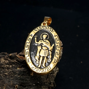 Détail du relief de la Vierge Marie sur un pendentif ovale en or et noir avec méandres