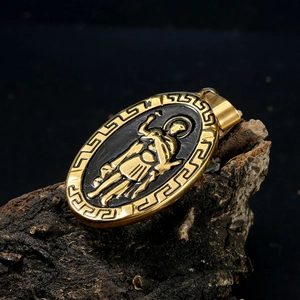 Vue détaillée d'un pendentif ovale doré avec relief de guerrier sur une écorce naturelle