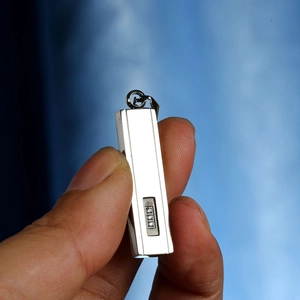 Detailed close-up of a silver rectangular pendant with three inset small zircons