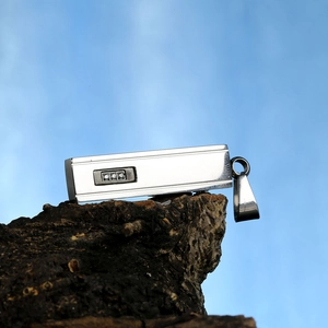 Detailed macro of a rectangular titanium steel pendant with three inlaid zircons