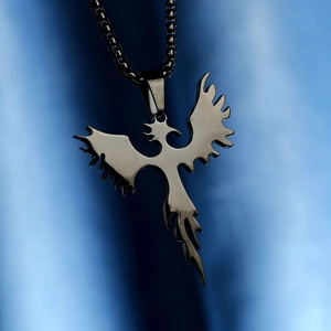 Detail of a black titanium steel phoenix pendant with a durable box chain on blue silk