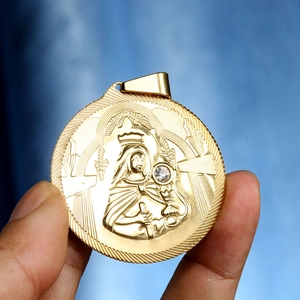 Détail macro d'un pendentif religieux doré rond avec relief de sainte et cristal