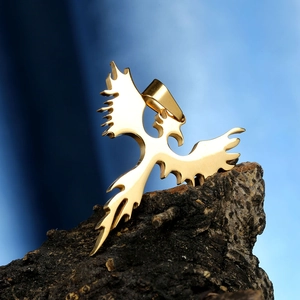 Golden titanium steel angel wing pendant necklace with polished finish on bark background