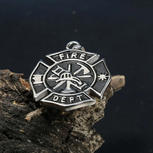 Macro shot of stainless steel fire department pendant with helmet and axe details