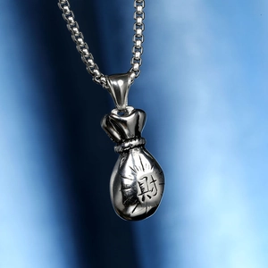 Pendentif sac d'argent argenté avec caractère Richesse sur fond de tissu bleu chic