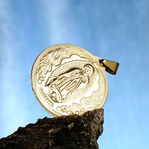 Relief détaillé de la Vierge Marie sur pendentif religieux doré avec ciel bleu en fond