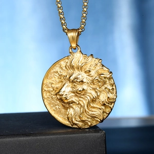 Macro shot of gold lion head relief on a circular stainless steel pendant with box chain