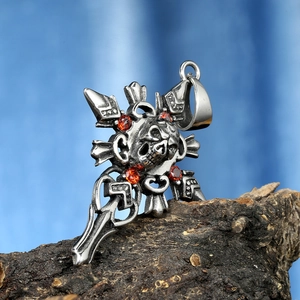 Gothic skull cross pendant with red gemstones on tree bark background, punk jewelry style