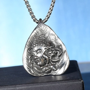 Retro stainless steel leaf pendant featuring a Buddha head and skull design on a metal chain