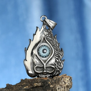 Pendentif vintage tête de mort en acier avec œil bleu et forme de flamme sur écorce