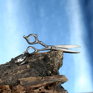 Detail of scissors pendant featuring realistic bark texture on stainless steel surface