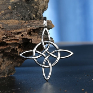 Pendentif noeud celtique vintage en acier argenté sur fond de bois naturel