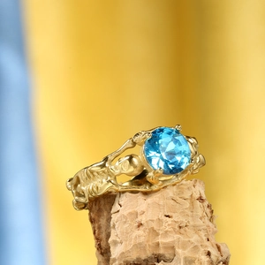 Anello gotico a teschio placcato oro con grande zircone blu rotondo incastonato