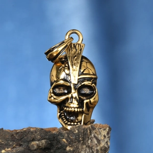 Macro view of vintage gold mohawk skull pendant with detailed metallic texture and finish