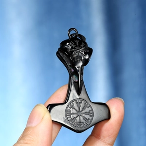 Dettaglio del ciondolo Mjölnir nero con rune vichinghe Vegvisir e motivi di teschi