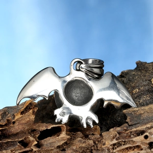 Macro shot of Gothic bat wing pendant with polished finish on textured wood base
