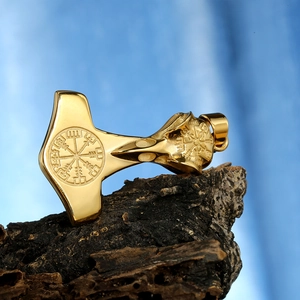 Dettaglio ciondolo Mjölnir vichingo dorato con rune Vegvisir su sfondo di corteccia