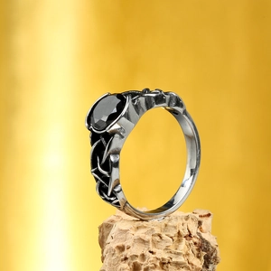 Vintage Celtic Knot heart ring in steel featuring an oval black gemstone on wood base