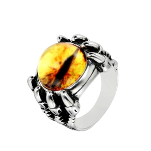 Macro shot of punk dragon claw ring with yellow evil eye stone and silver finish