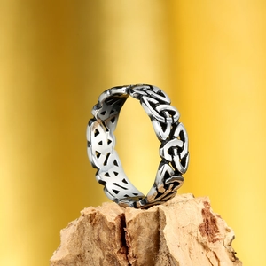 Macro view of vintage Viking Celtic knot hollowed-out ring on rustic wood background